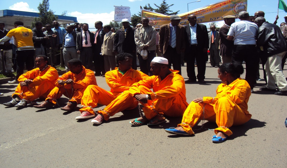 የሰልፉ መሪዎቸ በተምሳሌታዊ አለባበስና ሁኔታ (ከስር ተቀምጠው የሚታዩት ወጣቶች በደህንነት ተብዬዎች የሚሳደዱት ናቸው)