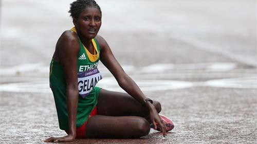 አትሌት ቲኪ ገላና የወርቅ ሜዳሊያ ማግኘቷን ካረጋገጠች በኋላ ዕረፍት ስታደርግ Gold medalist Tiki Gelana of Ethiopia rests at the finish line