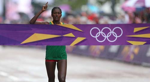 አትሌት ቲኪ ገላና ክብረወሰን ስታስመዘግብ Tiki Gelana of Ethiopia celebrates as she crosses the finish line to win the gold