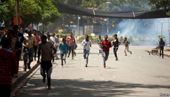 Protesters run from tear gas being fired by police during Irreecha, the thanks giving festival of the Oromo people in Bishoftu town of Oromia region, Ethiopia, October 2, 2016. Protest in Oromia, Ethiopia.