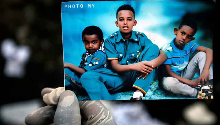 A rescue worker holds a photo of missing children.